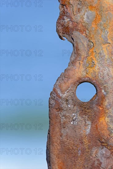 Old rusty sheet pile wall element with hole