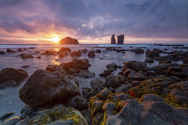 Sunset on a stony coast with huge rocks in the Atlantic Ocean