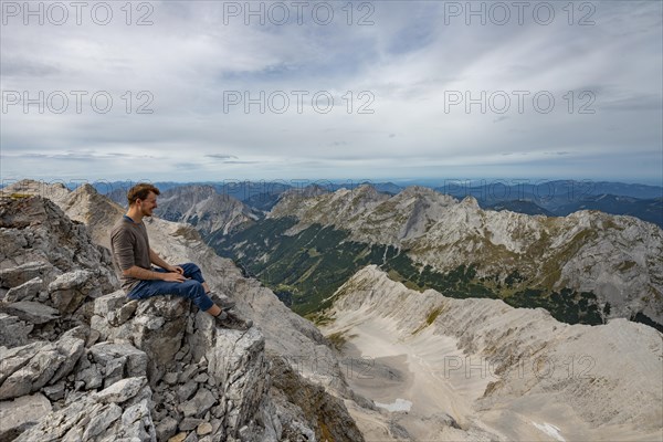 Hiker sitting at the summit of the Birkkarspitze