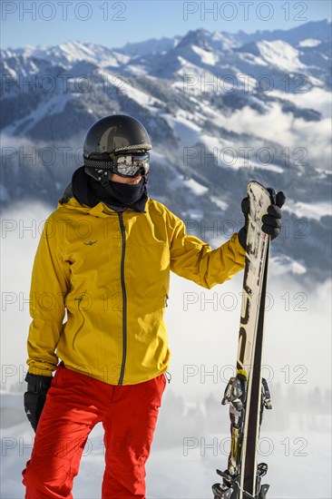 Skier standing at the ski slope holding ski