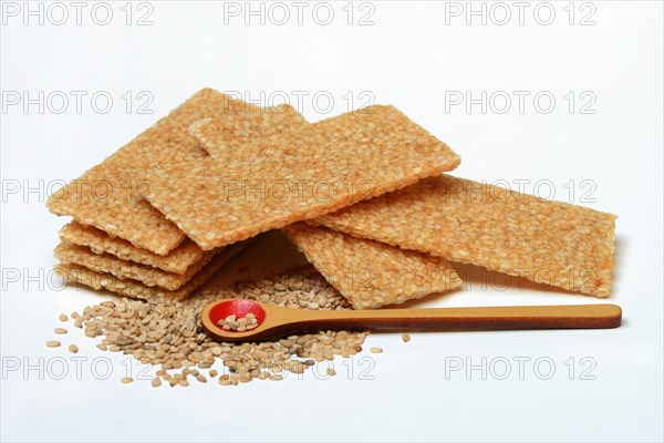 Sesame bar and sesame seeds with wooden spoon