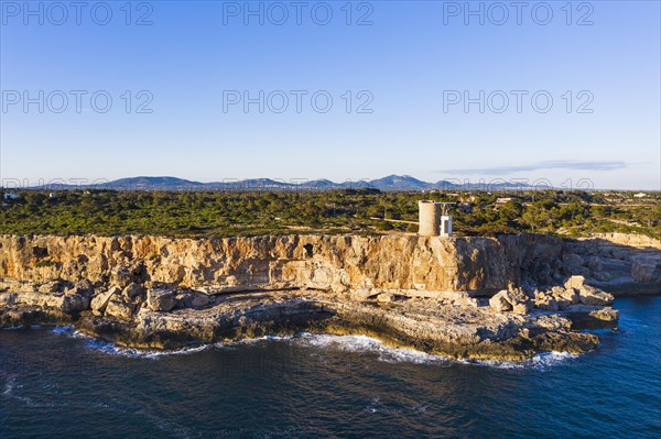 Steep coast with watchtower Torre d'en Beu near Cala Figuera