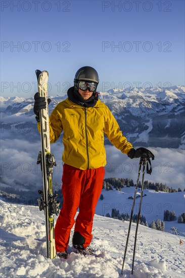 Skier standing at the ski slope holding ski