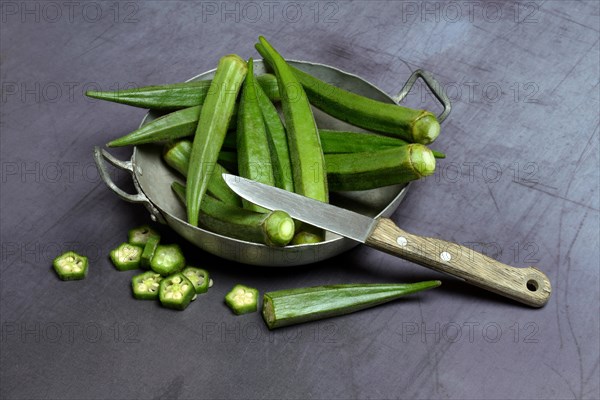 Okras in bowl and kitchen knife