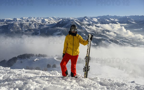 Skier standing at the ski slope holding ski