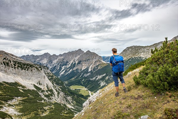 Hiker looks into the Karwendel valley with Raffelspitze and Hochkarspitze
