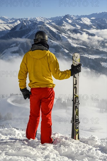 Skier standing at the ski slope holding ski