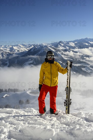 Skier standing at the ski slope holding ski