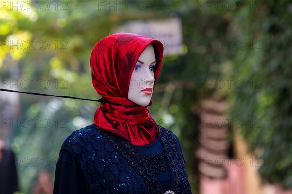 Strikingly decorated mannequin is secured against falling over with a rope