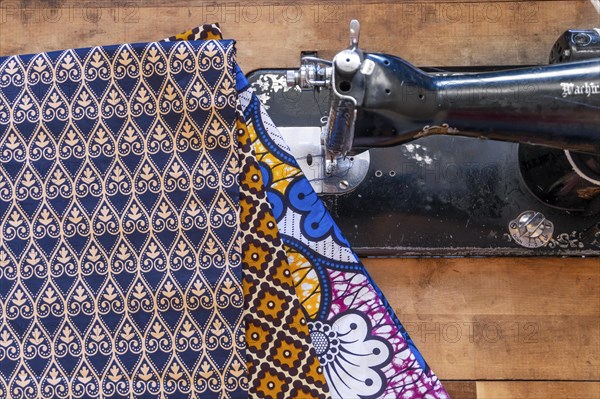 Sewing machine and African fabrics in seamstress workshop