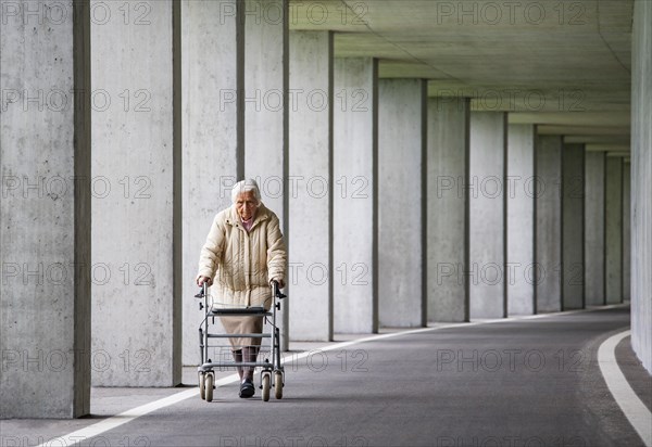 Senior citizen with walker walks in an underpass