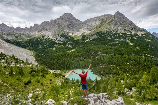 Young man stretches arms in the air