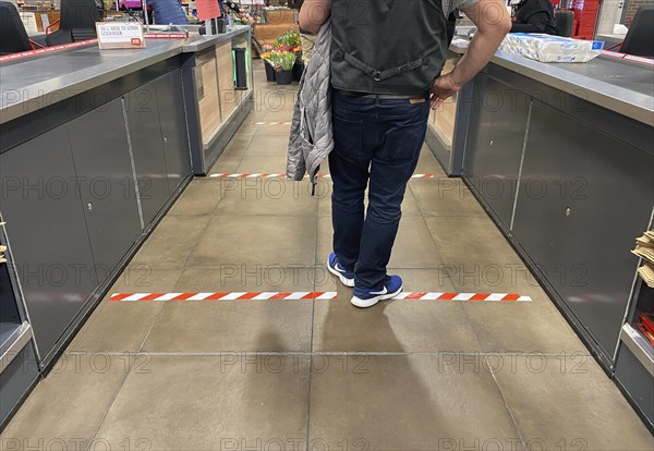 Social Distancing by means of warning strips at the checkout in the supermarket due to coronavirus