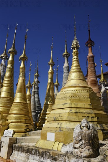 Guardian figure in front of grave stupas