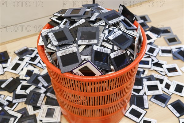 Framed 35mm slides in overflowing wastepaper basket and on floor