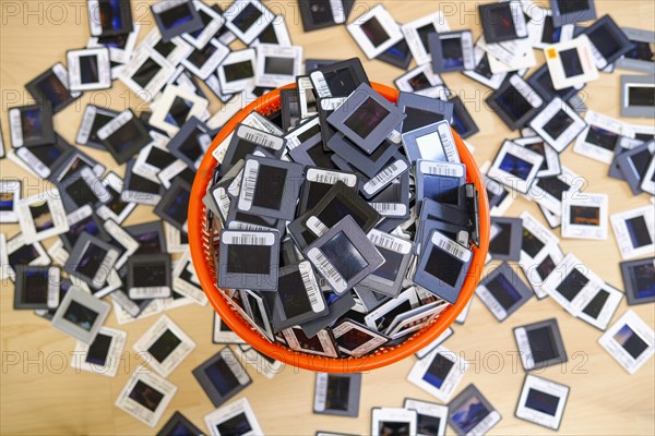 Framed 35mm slides in overflowing wastepaper basket and on floor