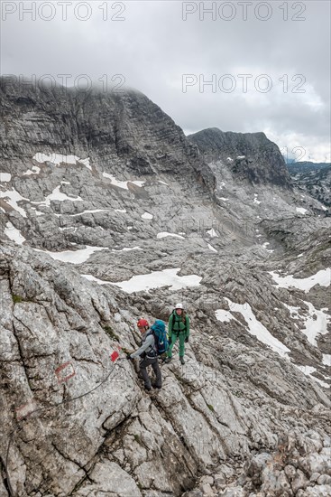 Two mountaineers on marked secured route on rock face