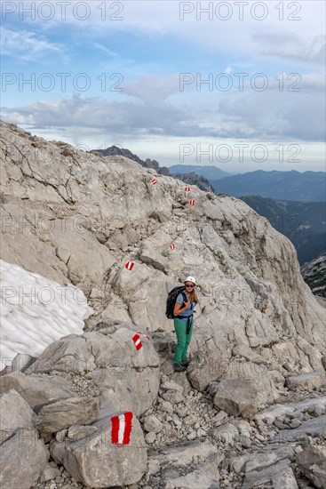 Mountaineer on marked route through rocky alpine terrain