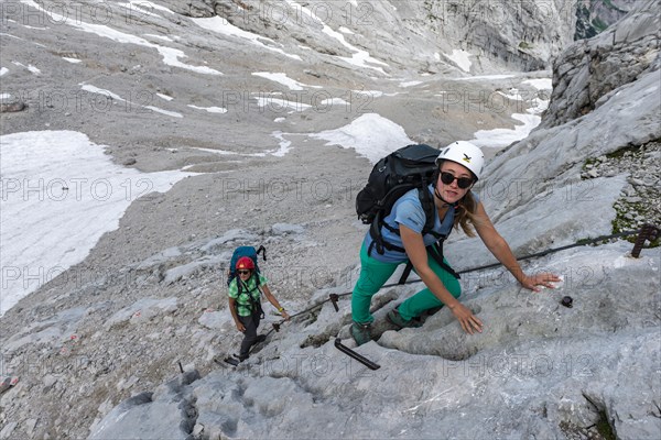 Female mountaineers climbing rock face