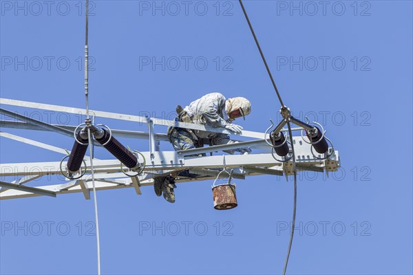 Painter on high voltage pylon