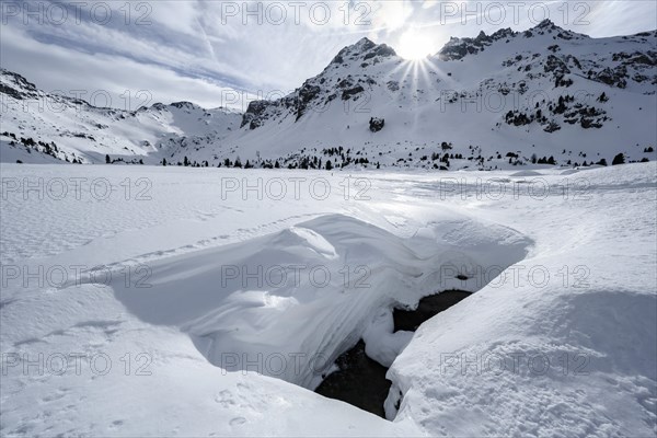 Sun shines over snow-covered mountain peaks