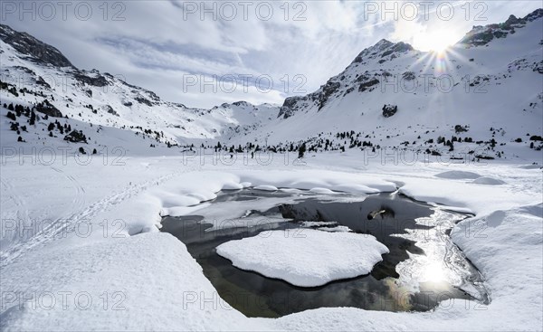 Sun shines over snow-covered mountain peaks