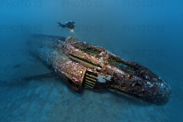 Diver looks at airplane wreck