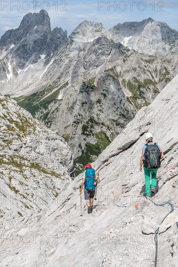 Hiker on a rocky route secured with a wire rope from Simonyhuette to Adamekhuette