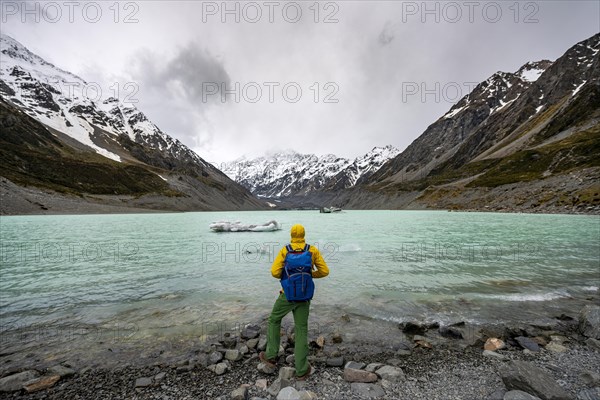 Hiker views Hooker Lake in Hooker Valley, Mount Cook National Park