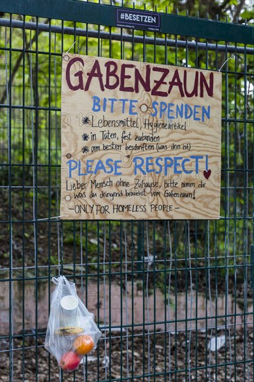 Gift fence, bag with food for the needy hangs on wire fence