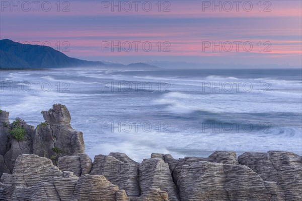 Rock formations of the Pancake Rocks in front of the ocean waves in the evening light, Paparoa National Park