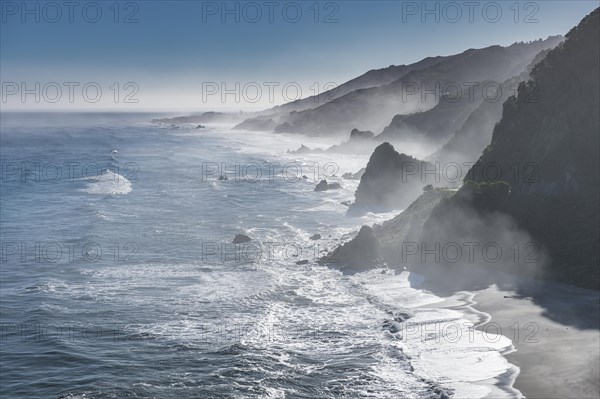 View from the coastal road, unspoiled rocky coast with sea spray