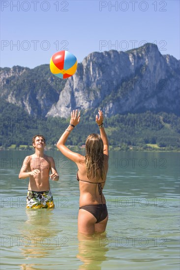 Two teenagers play with water polo in a lake, 18 years