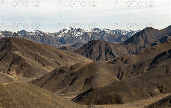 Barren mountain landscape and snow-capped mountain peaks, Lindis Pass