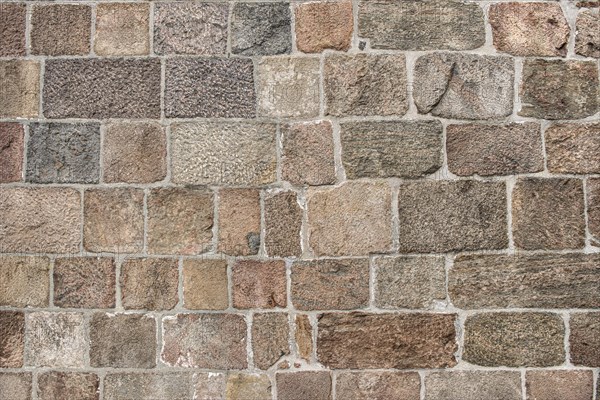 Wall of grouted stone blocks of different sizes, background