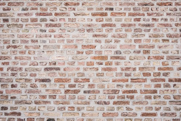 Grouted brick wall made of differently coloured bricks, background
