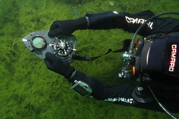 Divers in dry suits orientate themselves with compass in waters with poor visibility, Echinger Weiher