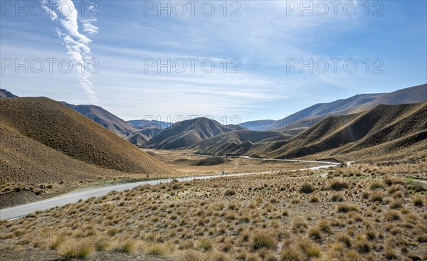 Barren mountain landscape with tufts of grass, pass road