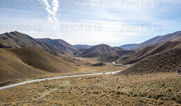 Barren mountain landscape with tufts of grass, pass road