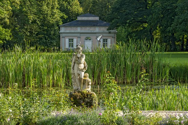 Pond with sculpture of the love goddess Venus with two doves in front of Chinese pavilion, tea house