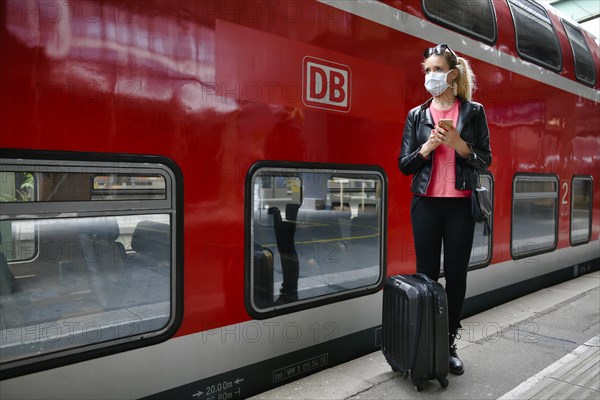 Woman with face mask, waiting for train