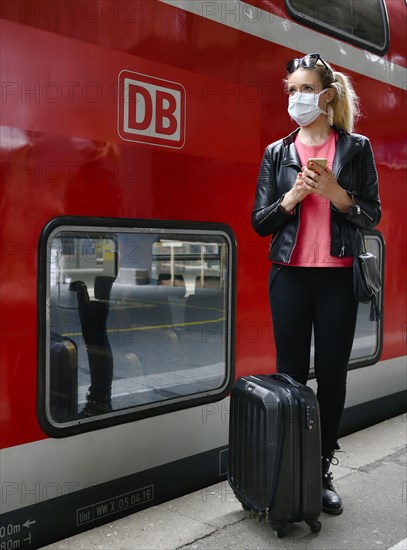 Woman with face mask, waiting for train