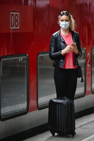 Woman with face mask, waiting for train