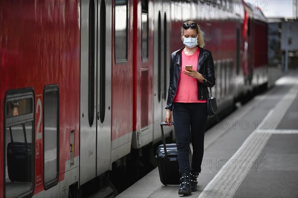 Woman with face mask, waiting for train