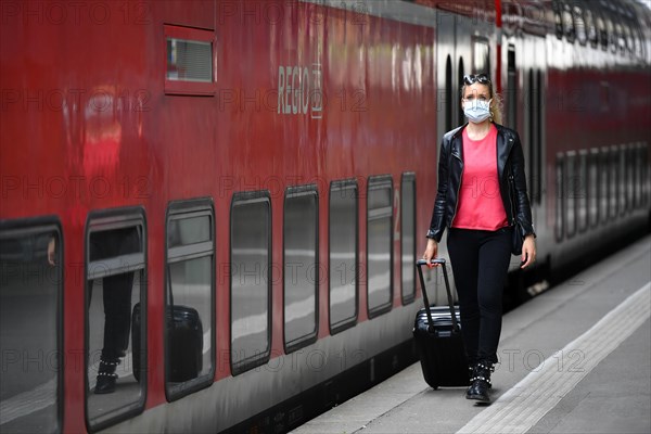 Woman with face mask, waiting for train