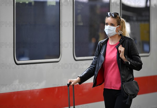 Woman with face mask, waiting for train