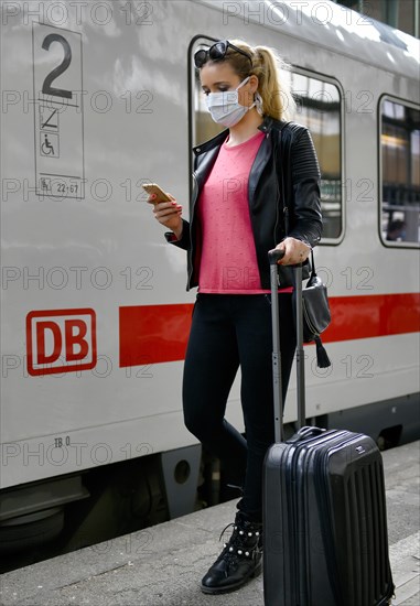 Woman with face mask, waiting for train