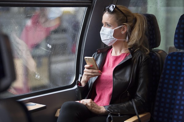 Woman with a face mask, sitting in Zug