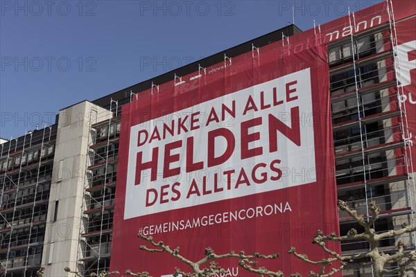 Large banner with thanks to the heroes of the Corona pandemic, on the scaffolding of a building