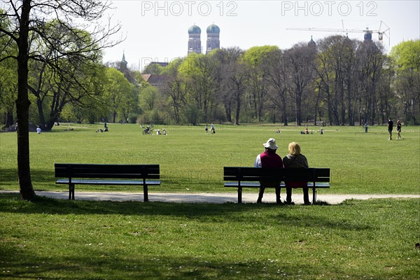 Couple sitting on a bench in the English Garden, Coronakrise Munich